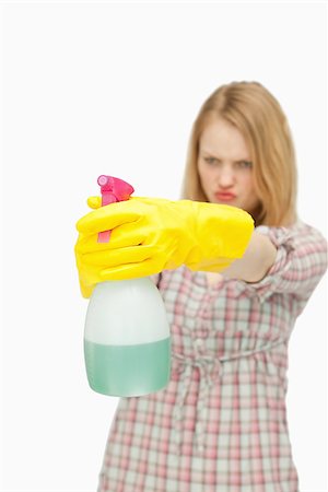 serious maid - Young woman holding a spray bottle against white background Stock Photo - Budget Royalty-Free & Subscription, Code: 400-06690176
