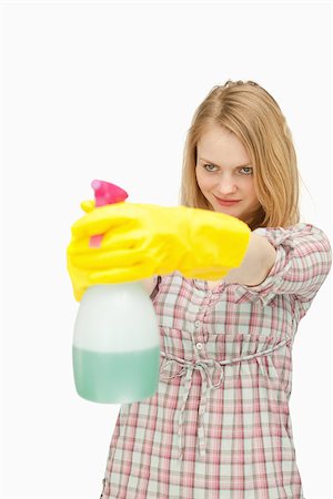 serious maid - Young woman smiling while holding a spray bottle against white background Stock Photo - Budget Royalty-Free & Subscription, Code: 400-06690177