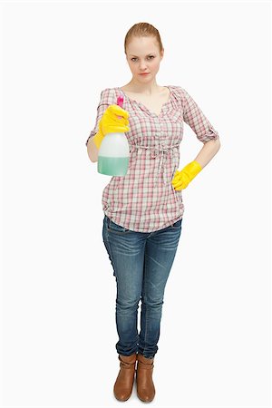serious maid - Woman standing while holding a spray bottle against white background Foto de stock - Super Valor sin royalties y Suscripción, Código: 400-06690204
