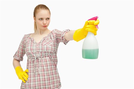 serious maid - Serious woman holding a spray bottle while looking away against white background Stock Photo - Budget Royalty-Free & Subscription, Code: 400-06690201