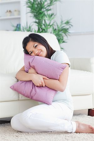 Woman holding tight a pillow in a living room Stock Photo - Budget Royalty-Free & Subscription, Code: 400-06690615