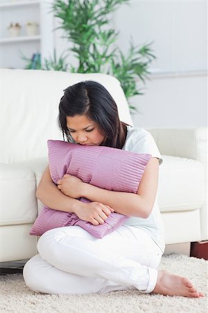 Sad woman holding a pillow in a living room Stock Photo - Budget Royalty-Free & Subscription, Code: 400-06690618