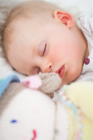 Cute baby sleeping next to her stuffed teddy bear in a bedroom Stock Photo - Budget Royalty-Free & Subscription, Code: 400-06690967