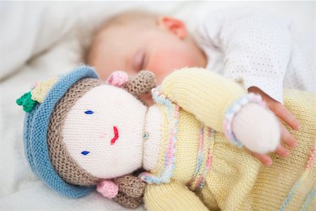 Baby sleeping while holding a plush doll in a bedroom Stock Photo - Budget Royalty-Free & Subscription, Code: 400-06690968