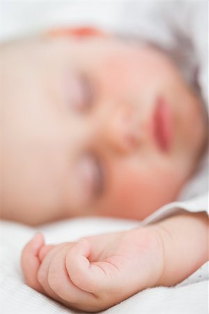 Baby lying on a bed while closing her eyes in a bright room Stock Photo - Budget Royalty-Free & Subscription, Code: 400-06690974