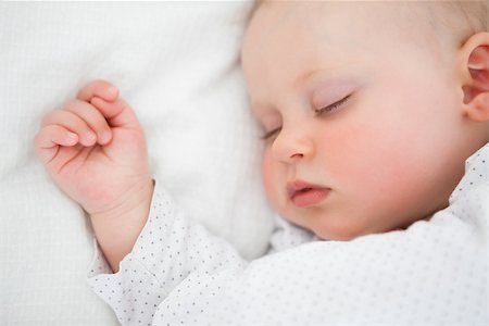 Peaceful baby lying on a bed while sleeping in a bright room Stock Photo - Budget Royalty-Free & Subscription, Code: 400-06690972