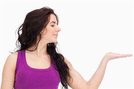 simsearch:400-06690896,k - Brunette in purple top looking at her palm against white background Stock Photo - Budget Royalty-Free & Subscription, Code: 400-06690996