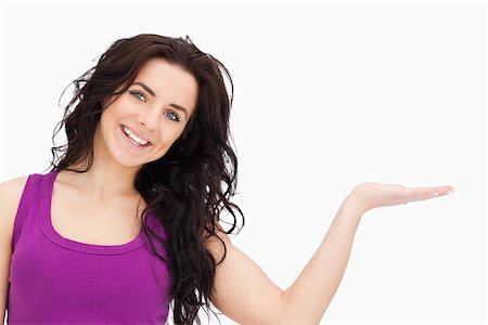 simsearch:400-06690896,k - Beautiful student in purple top presenting with her palm against white background Stock Photo - Budget Royalty-Free & Subscription, Code: 400-06690997