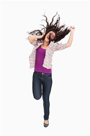 simsearch:400-06690896,k - Brunette jumping with her hair in the air against white background Stock Photo - Budget Royalty-Free & Subscription, Code: 400-06690998