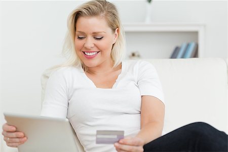 Casual woman sitting on the sofa using a tablet pc on the sofa Stock Photo - Budget Royalty-Free & Subscription, Code: 400-06691406