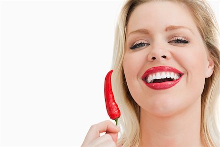 simsearch:400-04575822,k - Blonde woman holding a chili while laughing against a white background Photographie de stock - Aubaine LD & Abonnement, Code: 400-06691486