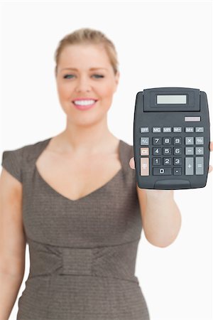 simsearch:400-04204809,k - Smiling woman showing a calculator against white background Stock Photo - Budget Royalty-Free & Subscription, Code: 400-06691535