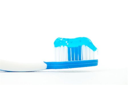 Blue toothpaste on a toothbrush against white background Stock Photo - Budget Royalty-Free & Subscription, Code: 400-06691710