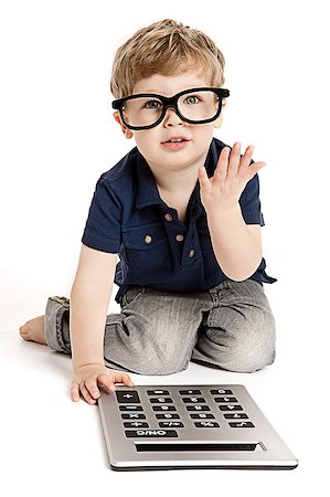 Cute boy wearing bit glasses doing maths with fingers and calculator. Photographie de stock - Aubaine LD & Abonnement, Code: 400-06692516