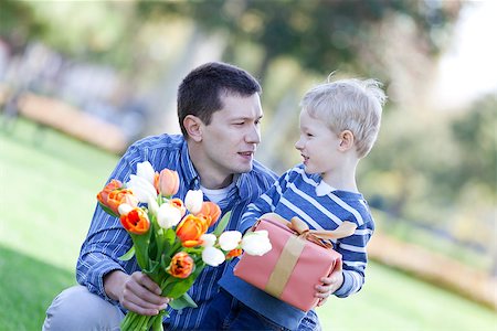 handsome young man and child offering a gift and flowers Stock Photo - Budget Royalty-Free & Subscription, Code: 400-06701371