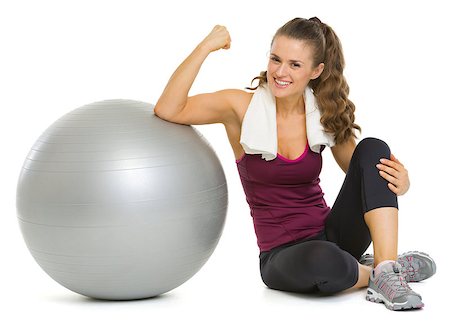 pic of girls with biceps - Smiling fitness young woman sitting near fitness ball and showing biceps Stock Photo - Budget Royalty-Free & Subscription, Code: 400-06701604