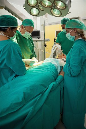Patient being operated by a team of surgeon in a surgery room Stock Photo - Budget Royalty-Free & Subscription, Code: 400-06734055