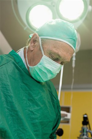 simsearch:400-06734621,k - Surgeon under a surgical light in a surgical room Stock Photo - Budget Royalty-Free & Subscription, Code: 400-06734058