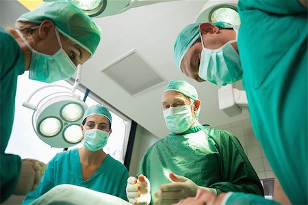 simsearch:400-06734621,k - Surgical team working on a bleeding patient in a surgical room Stock Photo - Budget Royalty-Free & Subscription, Code: 400-06734067
