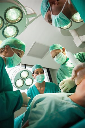 simsearch:400-06734621,k - Medical team working on a bleeding patient in a surgical room Stock Photo - Budget Royalty-Free & Subscription, Code: 400-06734068