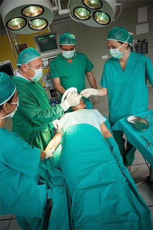 simsearch:400-06734621,k - Surgeon working on the arm of a patient with a team of surgeons in a surgical room Stock Photo - Budget Royalty-Free & Subscription, Code: 400-06734080