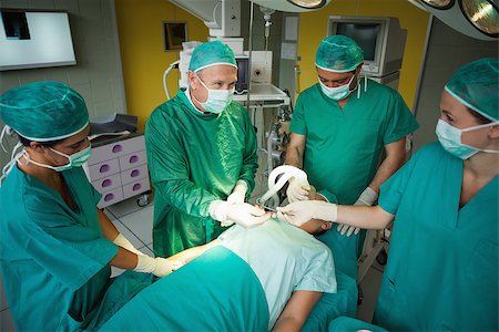 simsearch:400-06734621,k - Smiling surgeon taking a scalpel in a surgical room Stock Photo - Budget Royalty-Free & Subscription, Code: 400-06734081