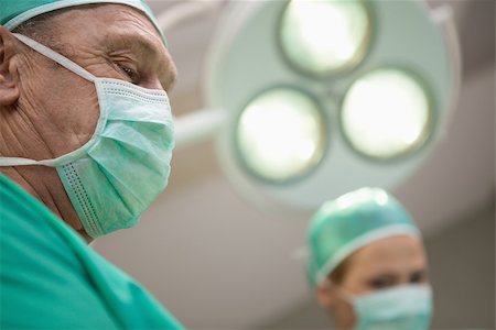 simsearch:400-06734621,k - Two surgeon standing under a surgical light in a surgical light Stock Photo - Budget Royalty-Free & Subscription, Code: 400-06734093