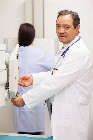 Doctor checking a machine while a patient is having a mammography in an examination room Stock Photo - Budget Royalty-Free & Subscription, Code: 400-06734128