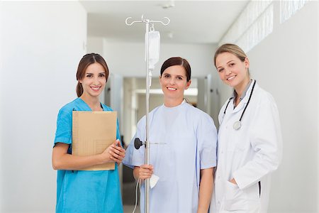 simsearch:400-06875952,k - Doctor standing in a hallway with a patient and a nurse in a hospital Stockbilder - Microstock & Abonnement, Bildnummer: 400-06734147