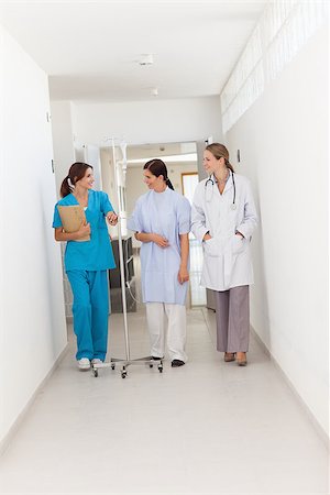 simsearch:400-06875952,k - Doctor walking with a patient and a nurse in a hallway Stockbilder - Microstock & Abonnement, Bildnummer: 400-06734148