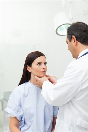 simsearch:400-06734647,k - Doctor touching the neck of a patient in an examination room Stock Photo - Budget Royalty-Free & Subscription, Code: 400-06734169