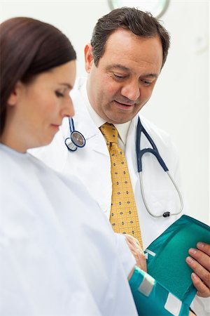 Doctor placing a sphygmomanometer around the arm of his patient in an examination room Stock Photo - Budget Royalty-Free & Subscription, Code: 400-06734162