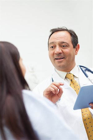 Smiling doctor talking with a patient while holding a tablet in an expression room Stock Photo - Budget Royalty-Free & Subscription, Code: 400-06734176