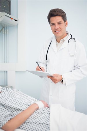 simsearch:400-06734647,k - Doctor writing on his chart in hospital ward Stock Photo - Budget Royalty-Free & Subscription, Code: 400-06734188