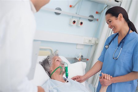 Nurse smiling to a patient while touching her hand in hospital ward Stock Photo - Budget Royalty-Free & Subscription, Code: 400-06734215