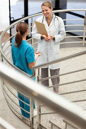 simsearch:400-06875952,k - Doctor holding a file while talking to a nurse in a stairwell Stockbilder - Microstock & Abonnement, Bildnummer: 400-06734231