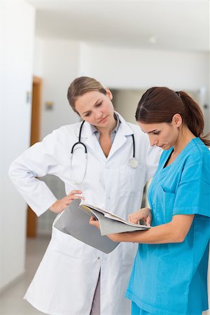 simsearch:400-06875952,k - Nurse and a doctor looking in a file in a hallway Stockbilder - Microstock & Abonnement, Bildnummer: 400-06734247