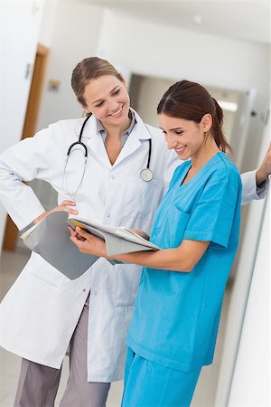 simsearch:400-06875952,k - Smiling nurse and a doctor looking in a file in a hospital Stockbilder - Microstock & Abonnement, Bildnummer: 400-06734248