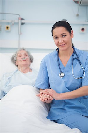 Nurse sitting on the bed next to a patient in hospital ward Stock Photo - Budget Royalty-Free & Subscription, Code: 400-06734283