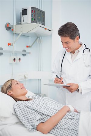 simsearch:400-06734647,k - Doctor standing while holding a chart in hospital ward Stock Photo - Budget Royalty-Free & Subscription, Code: 400-06734388