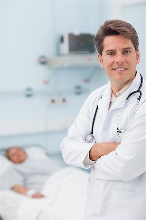 Doctor looking at camera with crossed arms in hospital ward Stock Photo - Budget Royalty-Free & Subscription, Code: 400-06734381