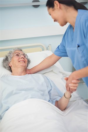 Patient smiling to a nurse while holding her hand in hospital ward Stock Photo - Budget Royalty-Free & Subscription, Code: 400-06734397