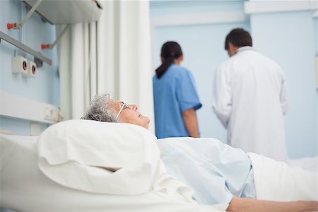 Patient lying on a bed next to a doctor and a nurse in hospital ward Stock Photo - Budget Royalty-Free & Subscription, Code: 400-06734399