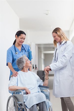 simsearch:400-07337135,k - Doctor looking at a patient on a wheelchair in hospital ward Stock Photo - Budget Royalty-Free & Subscription, Code: 400-06734432