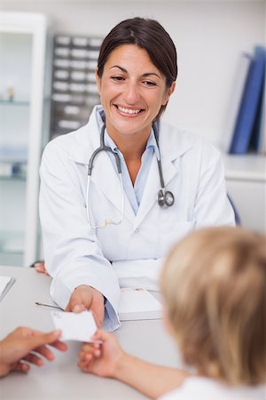 Smiling doctor giving a prescription to a patient in her medical office Stock Photo - Budget Royalty-Free & Subscription, Code: 400-06734530