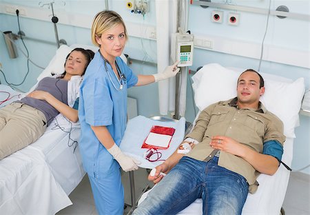 simsearch:400-06734658,k - Nurse touching monitor next to transfused patients in hospital ward Stock Photo - Budget Royalty-Free & Subscription, Code: 400-06734604