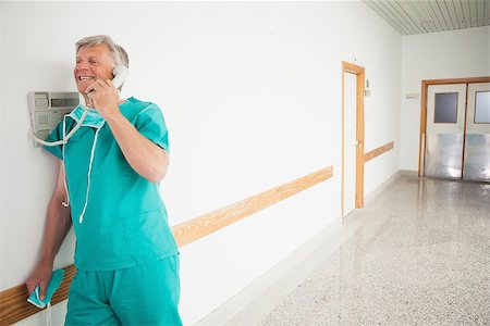 simsearch:400-06734621,k - Surgeon holding a phone in hospital hallway Stock Photo - Budget Royalty-Free & Subscription, Code: 400-06734631