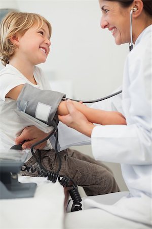 doctor measuring boy - Doctor examining blood pressure of a child in examination room Stock Photo - Budget Royalty-Free & Subscription, Code: 400-06734648