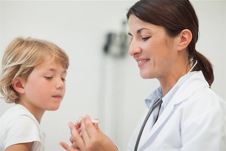 simsearch:400-06734741,k - Doctor looking at the thermometer in examination room Photographie de stock - Aubaine LD & Abonnement, Code: 400-06734649