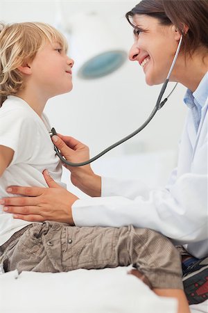 simsearch:400-06734741,k - Smiling doctor auscultating a child with a stethoscope in examination room Photographie de stock - Aubaine LD & Abonnement, Code: 400-06734642